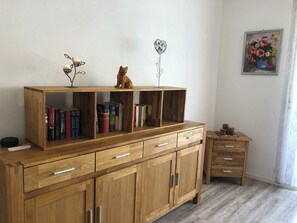 A wooden cabinet with books, a cat, and a decorative item. - Joanna vacation apartment with castle view in a central location (Bernkastel-Kues)