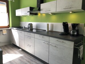 A modern kitchen with grey cabinets, a stainless steel sink, and a coffee maker. - Joanna vacation apartment with castle view in a central location (Bernkastel-Kues)