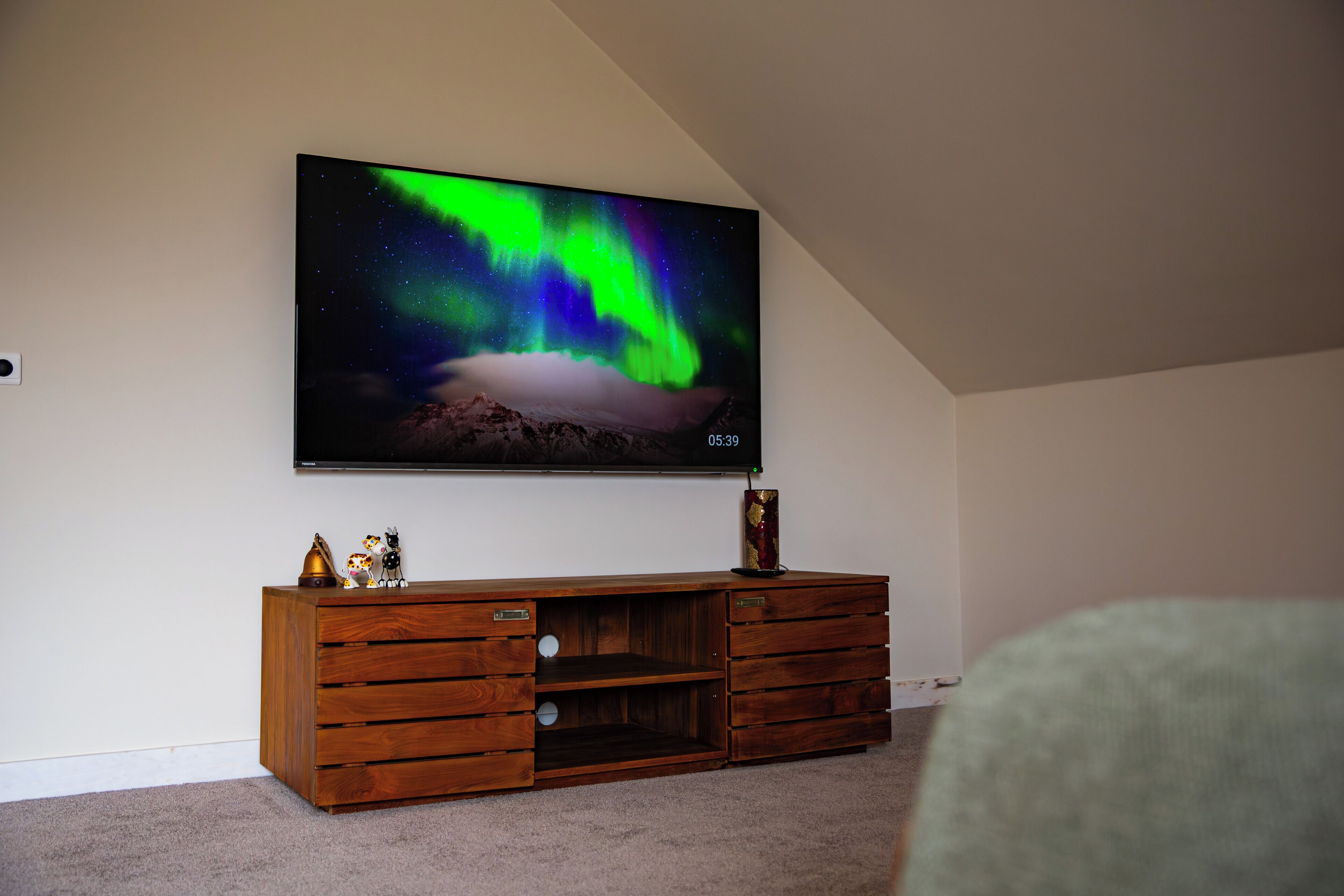 Seinälle asennettu televisio, jossa näkyy tähtitaivas ja revontulia.