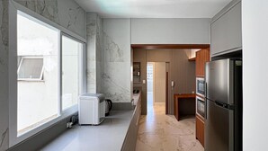 A modern kitchen with a large window, a built-in oven, and a refrigerator. - New apartment in the heart of Balneário Camboriú. Comfort and sophistication in the best location. (Balneário Camboriú)