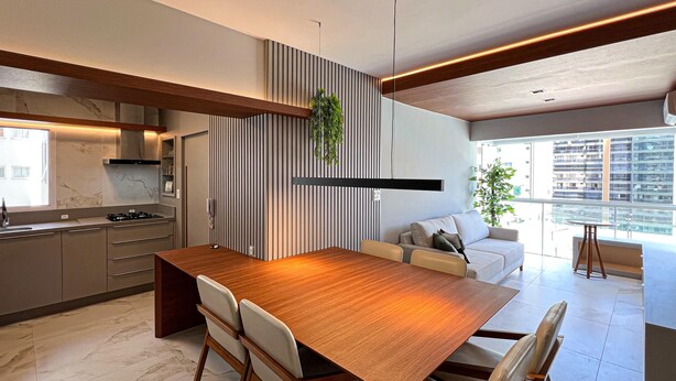 A modern kitchen with a wooden dining table, built-in cabinets, and a large window offering a city view. - New apartment in the heart of Balneário Camboriú. Comfort and sophistication in the best location. (Balneário Camboriú)