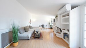 A modern living room with a sofa, coffee table, and dining area. - Casa Mia - Trastevere Rooftop Loft (Roma)