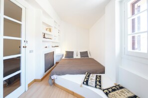 A bedroom with a bed, a window, and built-in shelving. - Casa Mia - Trastevere Rooftop Loft (Roma)