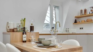 A modern kitchen with a wooden countertop, a built-in sink, and a window with a view. - Historical Apartment in the Heart of Paris - 4 (Paris)