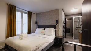Ett hotellrum med en säng, en dusch och utsikt över omgivningarna.