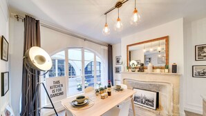 Un comedor con una mesa de madera, sillas, un ventanal grande y una chimenea.