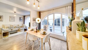 Una sala de estar moderna con comedor, ventanas grandes y vista a la ciudad.
