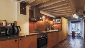 Une cuisine dotée de meubles en bois, d’une hotte aspirante en acier inoxydable, d’un four à micro-ondes et d’une machine à café.