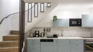 Una cucina moderna con mobili grigi, un forno a microonde integrato e una lavastoviglie.