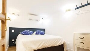 A bedroom with a bed, bedside table, and a wardrobe. - 1st District Louvre Notre Dame 8 Guests - AC (Paris)