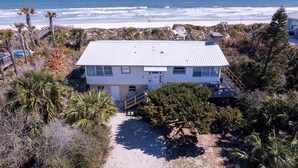 A coastal house with a metal roof, surrounded by palm trees and a beach view. - Private Beach Front: Rustic Dune Retreat (St. Augustine)
