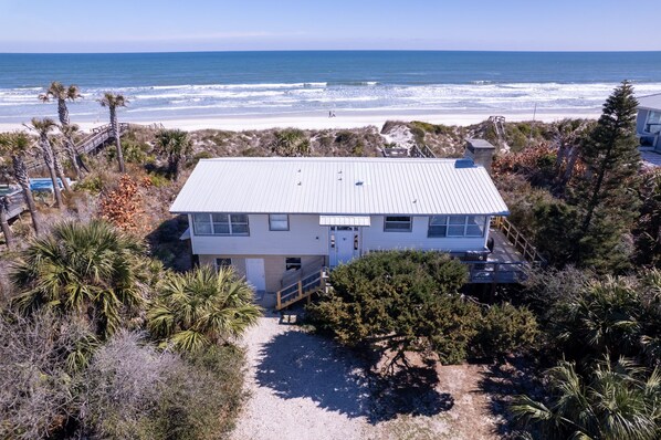 A coastal house with a metal roof, surrounded by palm trees and a beach view. - Private Beach Front: Rustic Dune Retreat (St. Augustine)