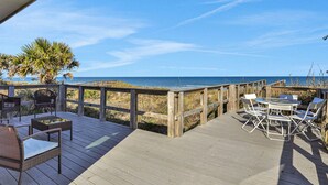 A wooden deck with outdoor furniture, overlooking a beach and ocean. - Private Beach Front: Rustic Dune Retreat (St. Augustine)
