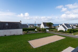 A residential area with houses, a lawn, and a view of the sea.