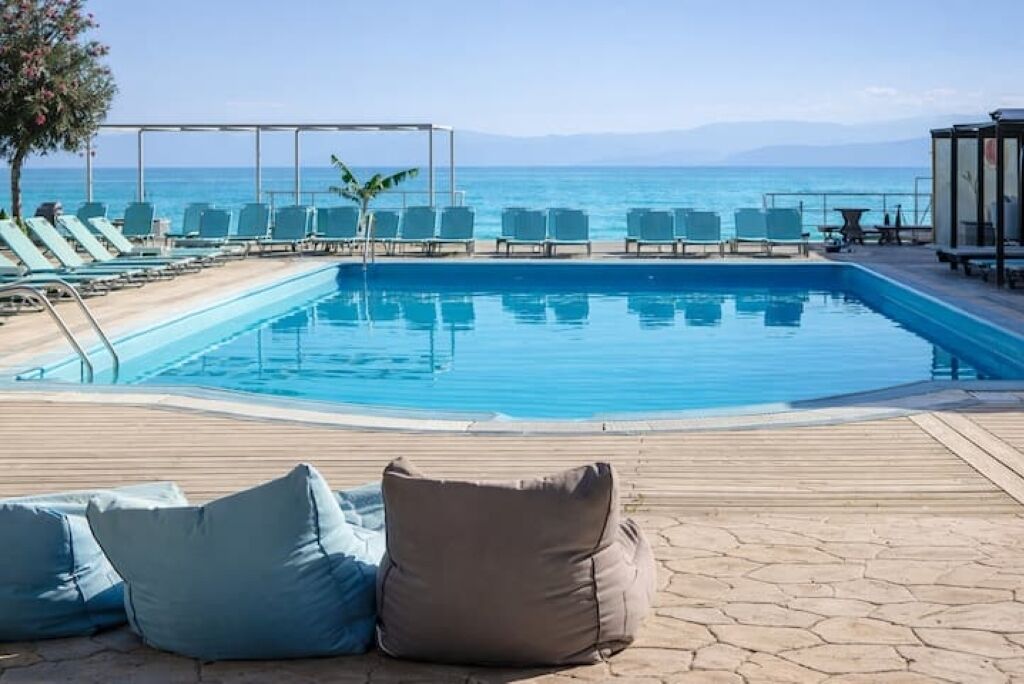 Ein Poolbereich mit Liegestühlen und Meerblick.