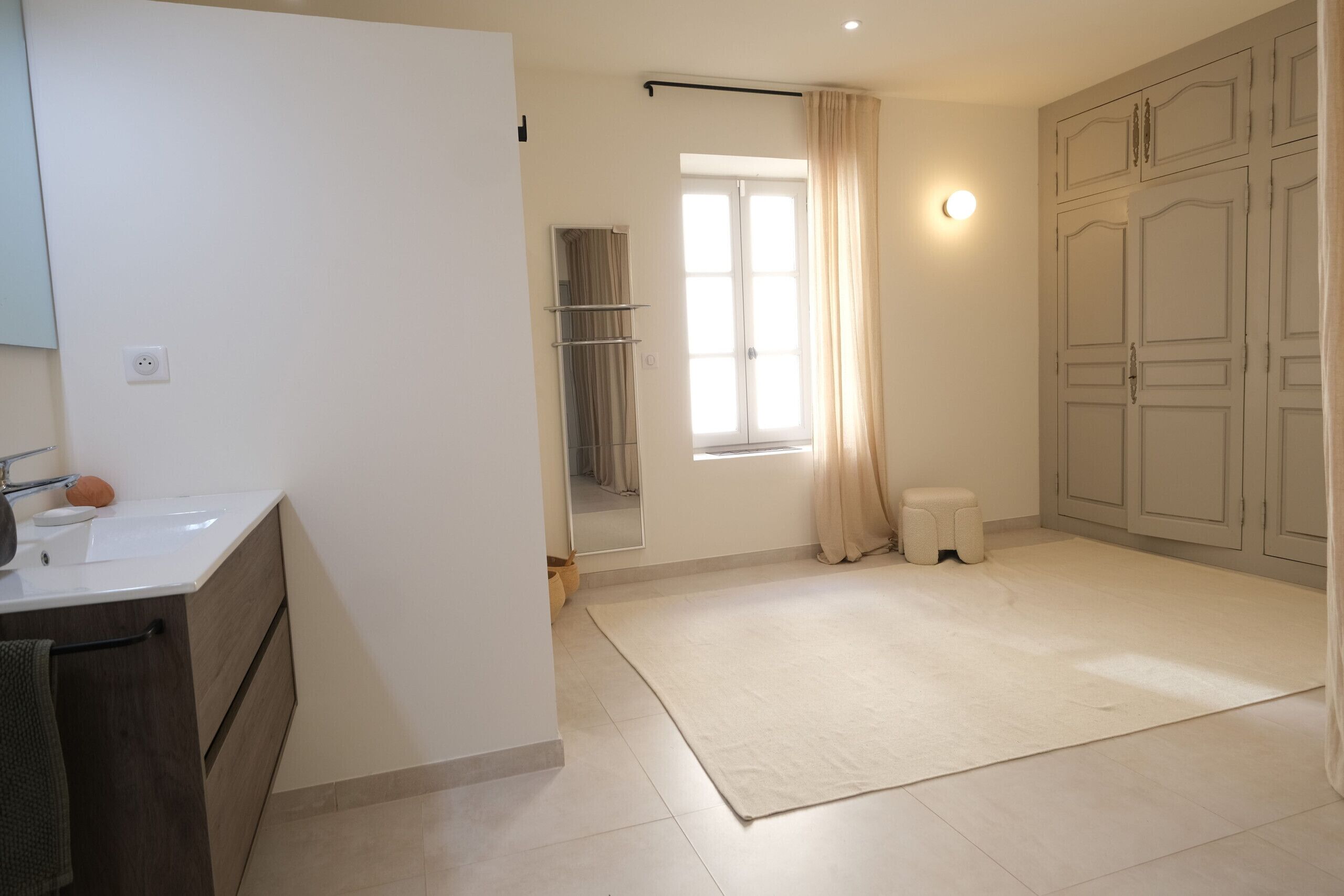 A bathroom with a sink, mirror, and towel rack.