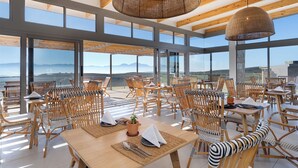A spacious dining area with high ceilings and large windows offering a view of the mountains. - Goats Window Luxury Safari Lodge Prestige Collection  (Bonnievale)