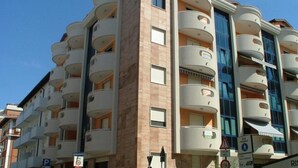 A multi-story hotel with balconies, a parking sign, and a restaurant sign. - Cozy Nest for Your Getaway in Grado (Grado)