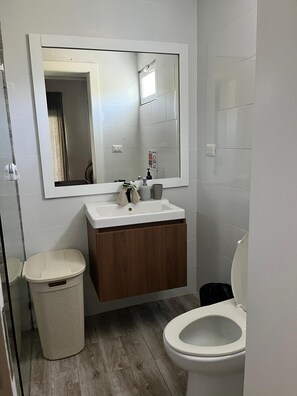 A bathroom with a white sink, wooden vanity, and a toilet. - La belle planque- 10 minutos de la Playa- PUNTA CANA (Punta Cana)