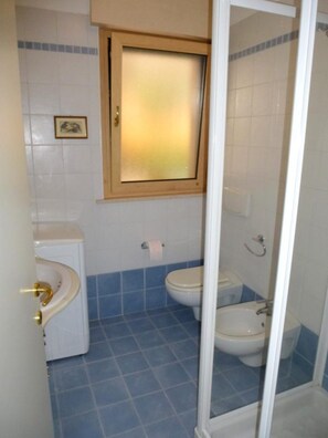 A bathroom with a toilet, sink, and shower area. - Lovely Private Garden Apartment for Four in Grado (Grado)