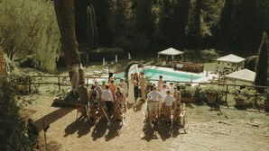 Cerimônia de casamento ao ar livre com piscina e jardim.