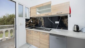 Una cocina moderna con armarios de madera, un salpicadero negro y un lavavajillas.