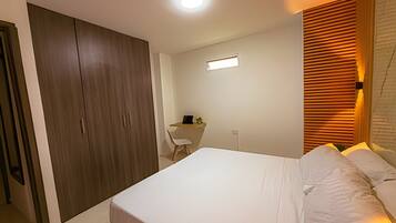Un dormitorio con cama, escritorio y armario.