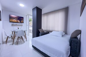 Une chambre d’hôtel moderne, équipée d’un lit, d’un bureau et d’une chaise.
