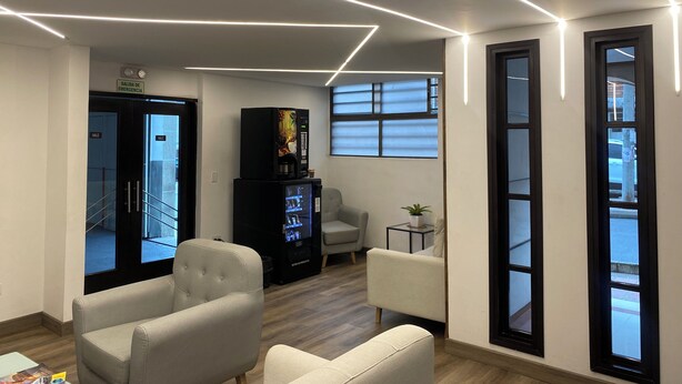 Un interior moderno con un sofá, una cafetera y un televisor.