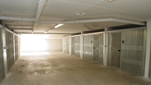 A long, empty corridor with metal lockers on both sides and a concrete floor. - Sweet Holiday Hideaway in Grado for Four Guests (Grado)