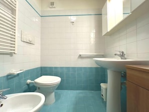 Ein Badezimmer mit Toilette, Waschbecken und Schrank.