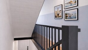 Un escalier avec des rampes noires et un plafond blanc.