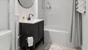 Une salle de bain moderne équipée de toilettes, d’un lavabo, d’un meuble-lavabo et d’une douche.