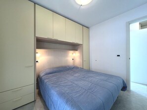 A bedroom with a bed, a wardrobe, and a ceiling light. - Spacious and Comfortable Holiday Home in Grado (Grado)
