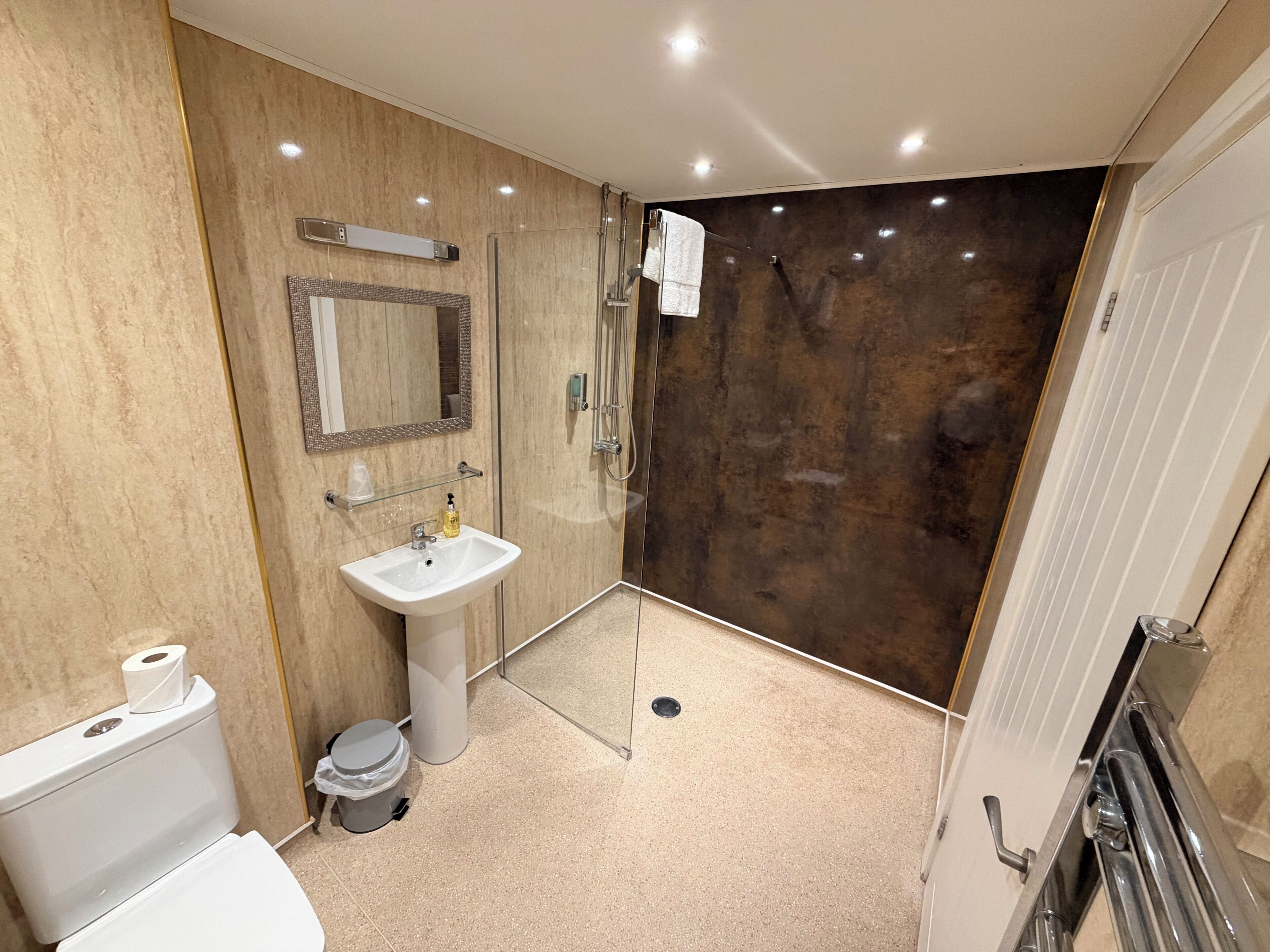 A modern bathroom with a toilet, sink, and shower.