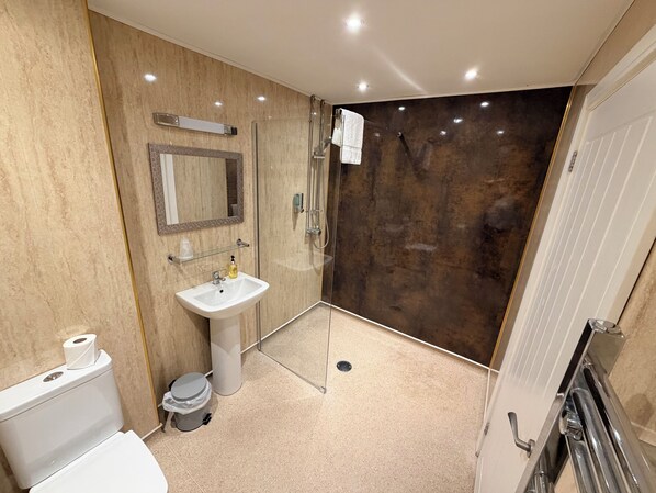 A modern bathroom with a toilet, sink, and shower.