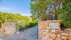 A stone gate with a sign reading "VIVANDA LIBERDADE" and a number "2" on a cobblestone path leading to a building. - Vivenda Liberdade in Carvoeiro (Lagoa)