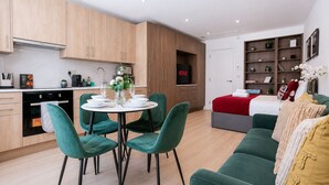 Um espaço moderno com área de refeições, cozinha e um aconchegante espaço para sentar.