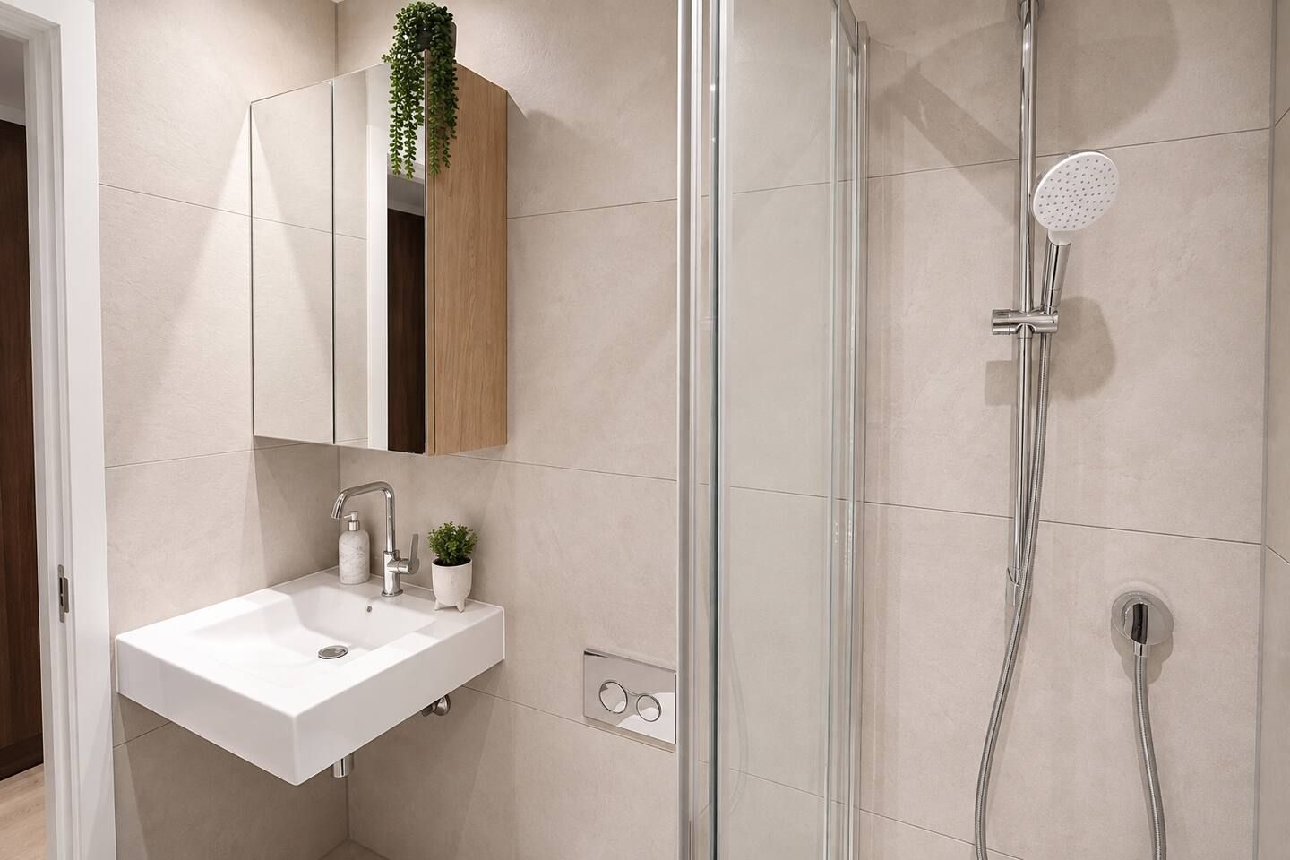 A modern bathroom with a glass-enclosed shower, a white sink, and a mirror above it.