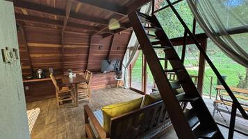 A wooden interior with a bed, a table, and a TV.