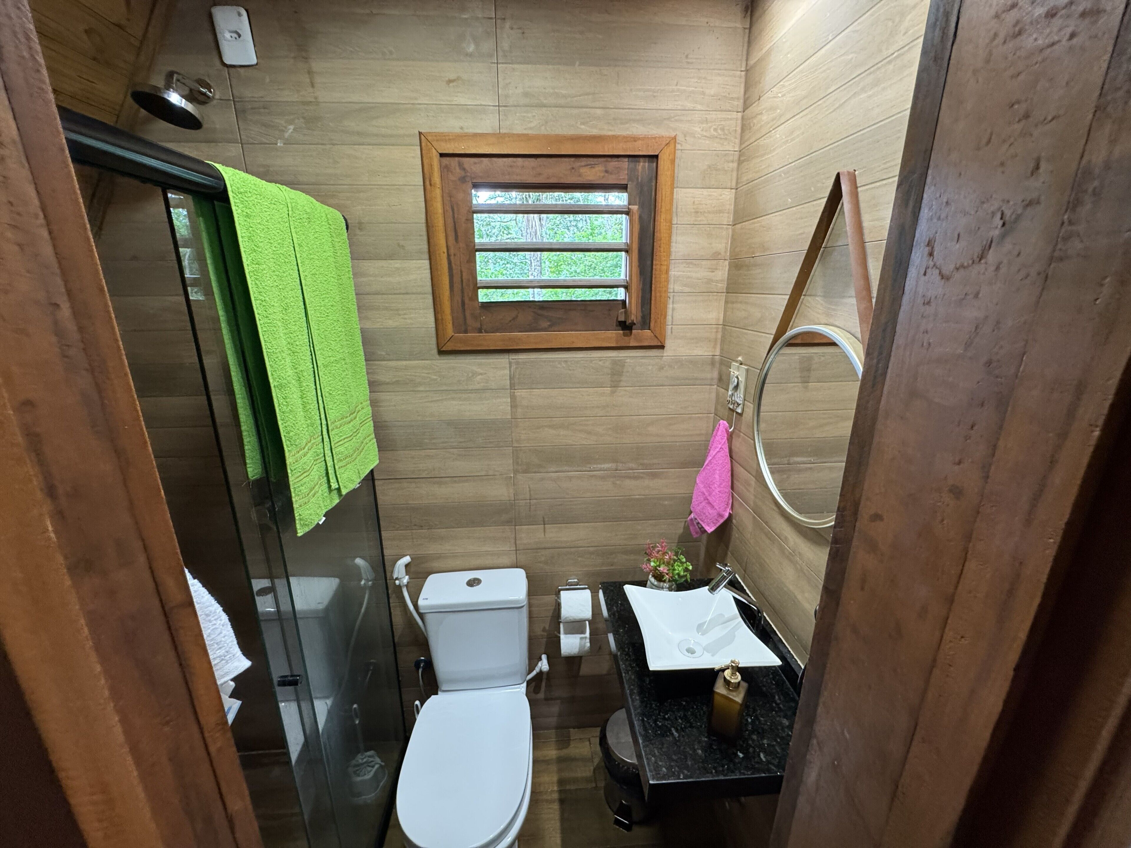 A compact bathroom with a toilet, sink, and shower.
