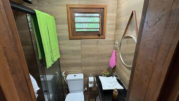 A compact bathroom with a toilet, sink, and shower.
