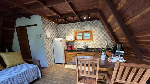Una cocina compacta con refrigerador, microondas y muebles de madera.