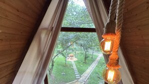 Un intérieur en bois avec une fenêtre donnant sur un sentier de jardin.