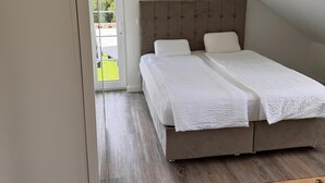 A bedroom with a large bed, a wooden floor, and a view of the outdoors. - Merzhausen Castle in the Taunus region near Frankfurt am Main - west wing (Usingen)