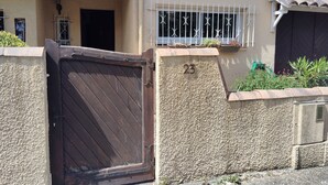 A gated entrance with a number '23' on the wall, a window with metal bars, and a tiled roof. - A warm and cozy home just 5 minutes from the city of Carcassonne. Quiet surroundings (CAZILHAC)