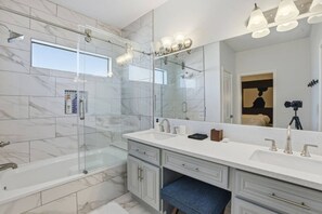 A modern bathroom with a glass-enclosed shower, a large mirror, and a vanity with a sink and cabinet. - SW Houston 3BR Sleeps 10 | 2 Living Areas (Houston)