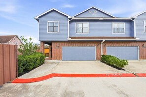 A two-story residential building with a garage, a red curb, and a no parking sign. - SW Houston 3BR Sleeps 10 | 2 Living Areas (Houston)
