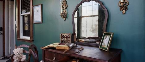 A dining area with a wooden table, chairs, and a large mirror.