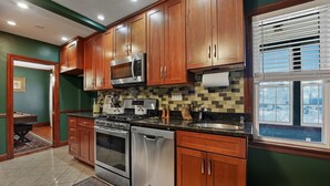 Una cocina moderna con armarios de madera, electrodomésticos de acero inoxidable y salpicadero de azulejos.